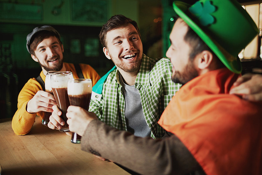 Multi-ethnic young men drinking beer and relaxing in pub