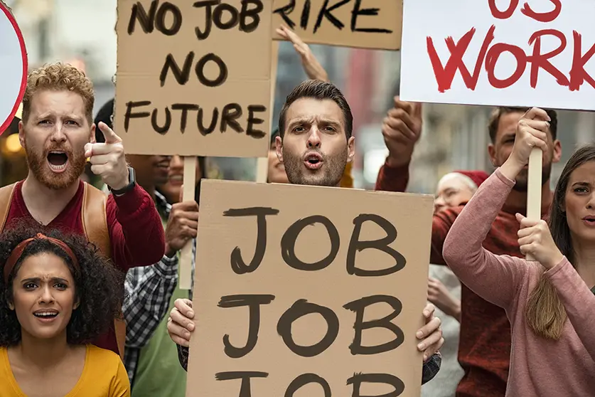 Group of demostrators with banners protest for job and equal salaries. Protestors people holding signs and posters on global strike for unemployment. Group of multiethnic men and women protesting outdoors with placards. 