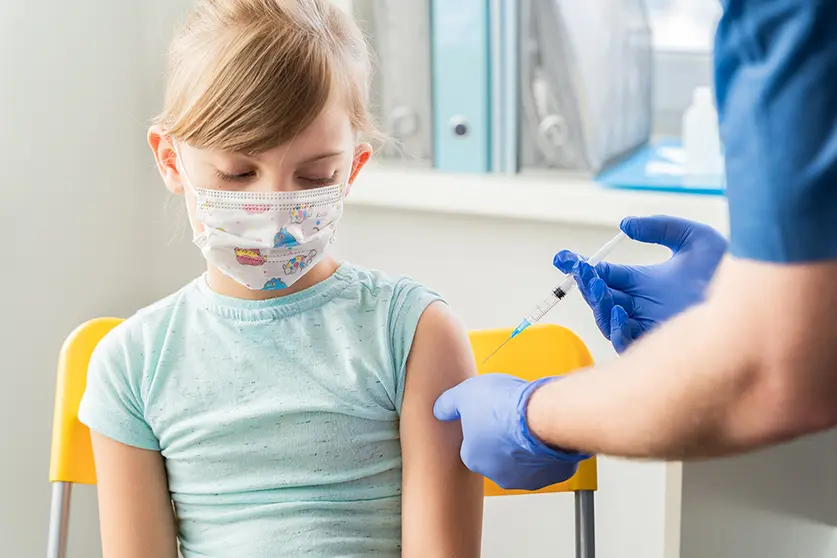 Little girl in the doctor's office is vaccinated. Syringe with vaccine against covid-19 coronavirus,flu,dangerous infectious diseases.Injection after clinical trials for human, child.Medicine concept.