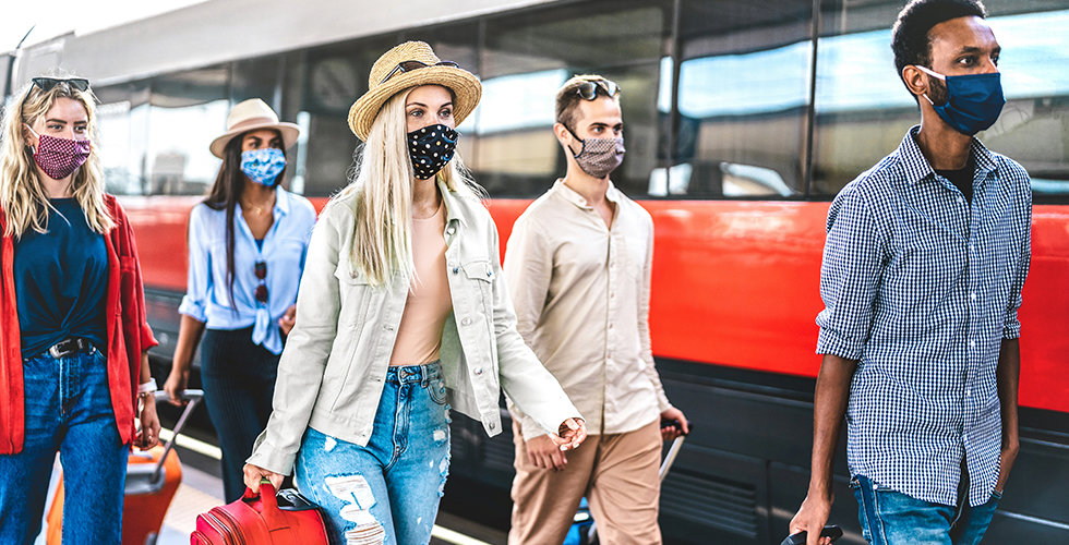 Multiracial friends group walking at railway station platform - New normal travel concept with young travelers on social distancing and face covered by protective mask - Focus on blonde girl with hat
