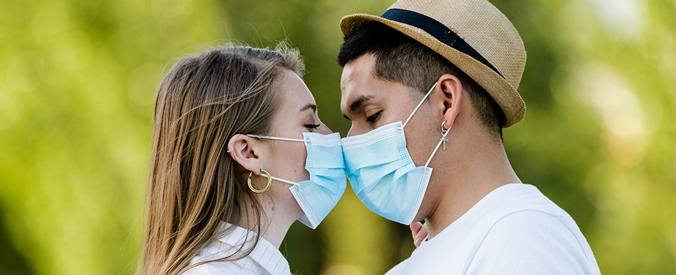 Couple with mask kissing at park