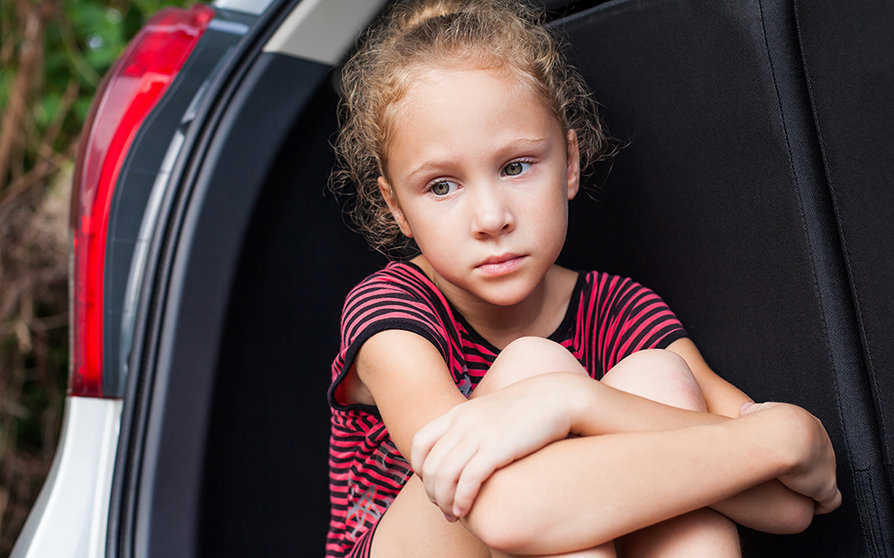 sad little girl sitting in the car